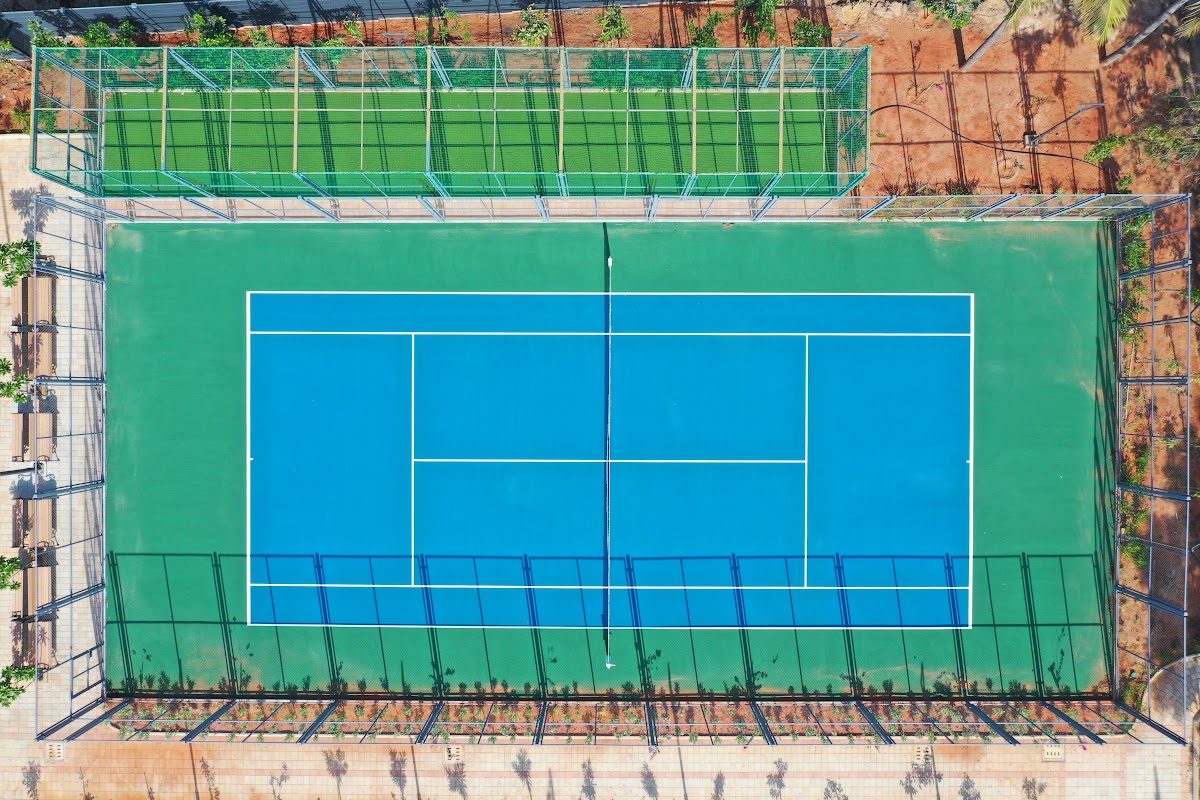 Blue and green synthetic tennis court seen from above