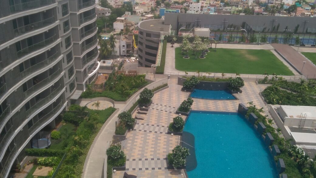 Swimming pool with tennis court and lawns on a podium